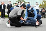 訓練で不審者の身柄を確保する境港署員＝６日、境港市竹内団地