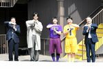 【美術館を盛り上げティー！】　県立美術館ロゴに使われている「Ｔ」を掲げ、パレード開会式を盛り上げるＧＥＮＥＲＡＴＩＯＮＳの片寄涼太さん（左から２人目）と、チョコレートプラネットの長田庄平さん（同３人目）と松尾駿さん（同４人目）ら＝３月２９日、倉吉市明治町の打吹回廊