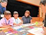 革の生地見本を見ながら職人と思い描くかばんづくりを進める槙原さん（左から３人目）＝豊岡市大磯町の但馬地域地場産業振興センター