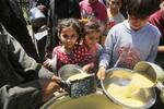 　ガザ地区中部デールバラハで、食料配給の列に並ぶ子どもたち＝１９日（ゲッティ＝共同）