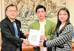 地域活性化プランを収録した卒業論文集を浜上町長（左）に手渡す生徒＝２４日、香美町役場