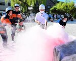 消防団員の手ほどきを受けながら消火器の使い方を訓練する住民＝２７日、香美町香住区若松