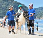 砂浜で乗馬に挑戦する園児＝１３日、岩美町陸上の東浜海水浴場