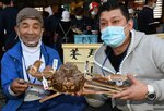 ２０２０年の初競りで、松葉ガニ１匹を２５０万円で競り落とした植村さん（右）