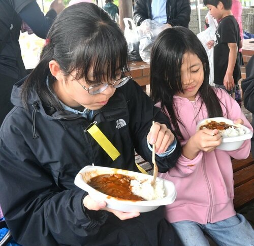 田植えを終えてカレーライスを味わう子どもら