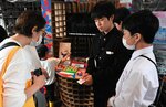 プロジェクトを紹介するカードや開発したおもちゃを見せ、来場者らに取り組みを紹介する生徒ら（右）＝２３日、大阪市此花区の夢洲