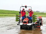 自動運転の田植え機に乗る学生たち