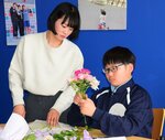 林さん（左）に教わりながら花束をつくる中学生＝１３日、北栄町図書館
