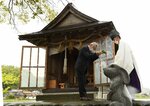 林宮司（右）から玉串を受け取る参拝者＝１５日、八頭町福本の福本白兎神社