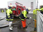 放水訓練でホースを掘抜消火栓につなぐ消防団員