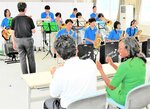 岩美高を訪れたジャマイカ大使（前列右）の前で生演奏を披露する吹奏楽部の生徒ら＝２０２３年９月