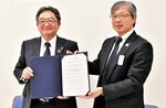 署名した協定書を手にする井上理事長（右）と安井理事長＝米子市淀江町今津の鳥取県生活協同組合西部支所