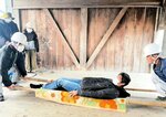 竹ざおと毛布で作った簡易担架で搬出訓練を行う参加者＝３日、新温泉町千原