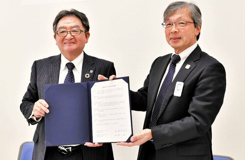 署名した協定書を手にする井上理事長（右）と安井理事長＝米子市淀江町今津の鳥取県生活協同組合西部支所