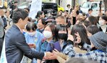 街頭演説に詰めかけた支持者ら。斎藤氏（左端）も笑顔で握手に応じた＝１０月