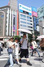 　気温「３２度」を示す東京・銀座の電光掲示（上）。東京都心は今年初の真夏日になった＝２０日午後