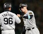 　６回、先制打を放ち、コーチとタッチを交わす阪神・佐藤輝＝甲子園