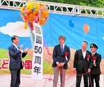 くす玉を割り、開園５０周年を祝う平井知事（左）ら＝５日、鳥取市浜坂のチュウブ鳥取砂丘こどもの国