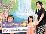 酒井さん（左）から受け取った記念品を手にする寺本さん＝２６日、境港市の夢みなとタワー