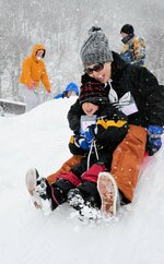 笑顔でそり遊びを楽しむ参加者＝１０日、香美町小代区新屋のとちのき村