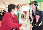 買い物客に啓発グッズを手渡す池上さん（右）＝２５日、豊岡市加広町のコープデイズ豊岡