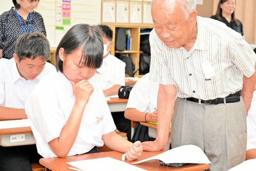 北尾さん（右）からの助言を参考に短歌を作る生徒ら＝４日、鳥取市青谷町青谷の青谷中