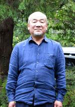 　仕事場の庭に立つ長野浩典さん。「メジロなど鳥がよく来て、見ていて飽きないんです」