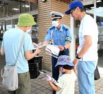 チラシと啓発グッズを手渡しながら安全運転を呼びかける署員＝８日、鳥取市湖山町東２丁目のサンマート湖山店