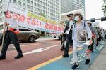 　戦争被害の救済を求めてデモ行進する人たち＝１９日午後、東京都内