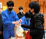 来場者に商品を手渡す生徒（左）＝１３日、鳥取市伏野の白兎養護学校