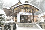拝殿に吹き込んだ雪をホウキで掃く神主＝24日午前11時54分、宇倍神社