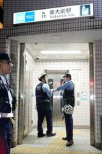 　東京メトロ南北線東大前駅の出入り口付近に集まる警察官＝７日午後８時３分、東京都文京区
