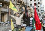 　イスラエルとレバノン両政府が停戦で合意し、ヒズボラの旗を掲げる人たち＝２７日、レバノン・ベイルート南部（ロイター＝共同）