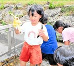 素早く逃げ回るアユを両手に握り、喜ぶ子どもたち＝１７日、新温泉町七釜