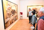 金属廃品を主題に描いた作品に見入る来館者