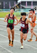 男子　鳥取城北は２区前田（左）が区間賞の走りで３区永見にトップでたすきをつなぐ＝竜ケ山陸上競技場