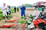 トラクターに装着した「ねぎ丸くん」の仕組みを説明する石井チーム長（中央）＝４月２８日、鳥取市国府町