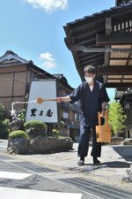 涼を求めて打ち水をする岩井屋のスタッフ＝２２日、岩美町岩井