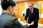 中山専務理事（右）に依頼文書を手渡す松崎事務局長＝１８日、鳥取市本町３丁目の県商工会議所連合会