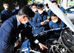ハイブリッド車の高電圧ケーブルの位置について説明を受ける機動隊員＝１５日、鳥取市伏野の機動隊敷地内