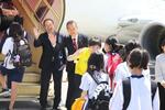 　周遊フライトへ向かう児童たちを見送る日航成田空港支店の真行寺誠副支店長（左）ら＝２４日午前、千葉県成田市