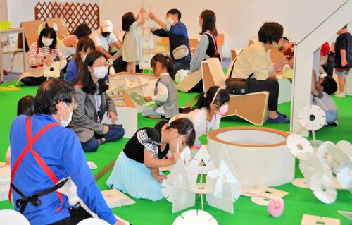 ダンボールを立体的に組み合わせて遊ぶ子どもら