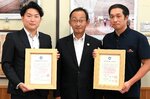 足羽教育長（中央）から協定証を受け取った西根社長（左）と荒田社長＝２３日、鳥取県庁
