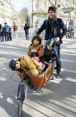 　３人の子どもを自転車のかごに乗せる男性＝３月、パリ（共同）