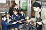 チョコレートが入った啓発グッズを来店客に手渡す園児たち＝１４日、鳥取市晩稲のイオン鳥取北店