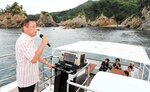 浦富海岸の島を巡りながら、歌声を響かせるモニター客（左）＝１４日、岩美町田後付近の浦富海岸