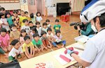 クロマグロを切る様子を興味深そうに見る園児たち＝１４日、境港市渡町