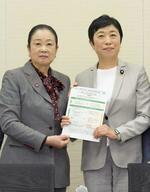 　選択的夫婦別姓を巡り、自民党の推進派議員連盟の土屋品子会長代行（左）に、民法改正案要綱を手渡す立憲民主党の辻元清美代表代行＝４月１５日、国会