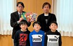 永瀬館長（後列左）に本を手渡した子どもたち