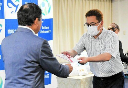 武中院長（手前左）に目録を手渡す奥洞代表